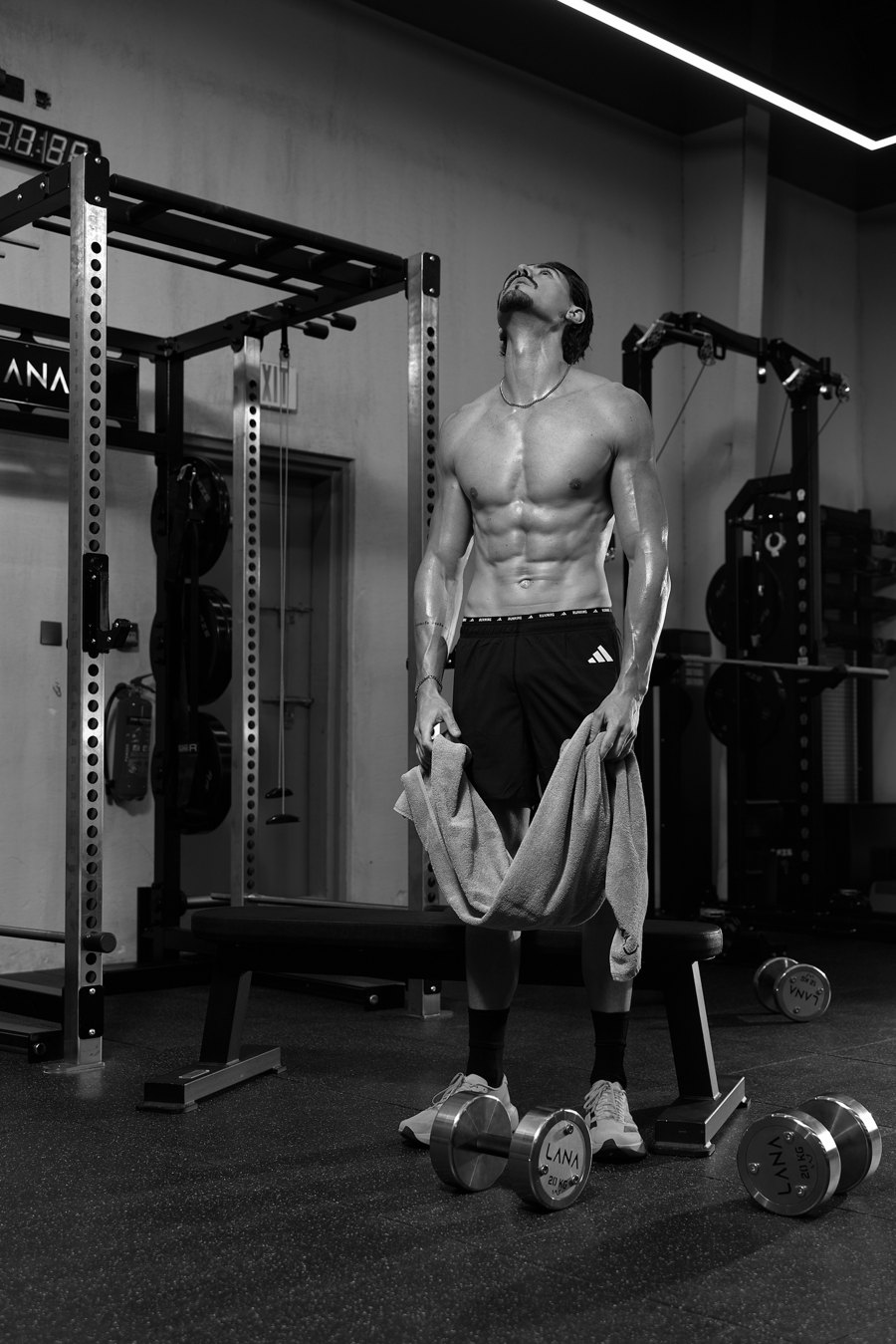 Robbie in the gym holding a towel, looking up