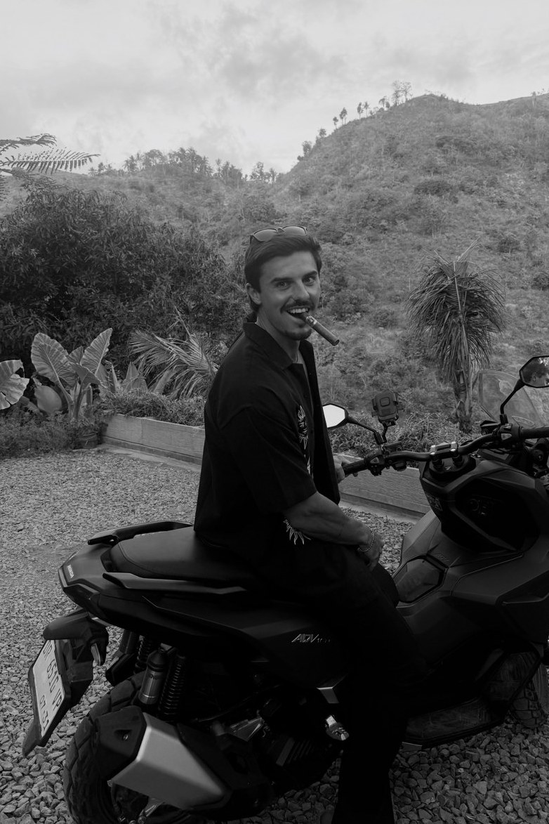 Robbie on a scooter in Bali, smiling with a cigar